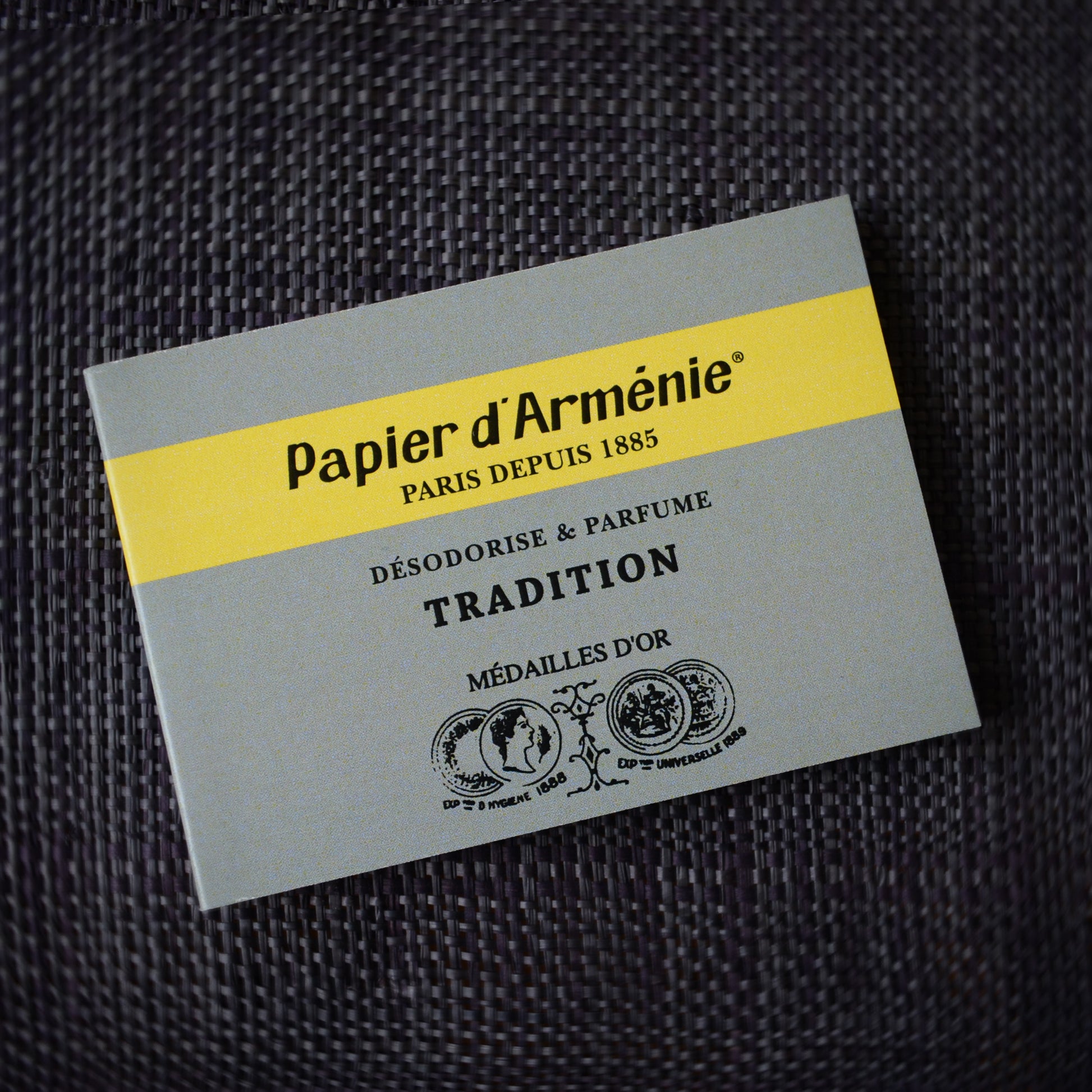 A booklet of traditional Papier d'Armenie on black woven fabric background.